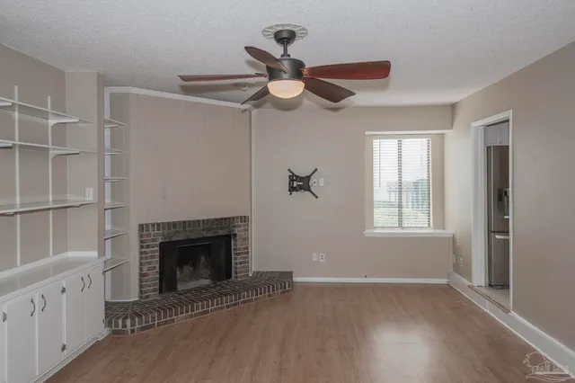 a view of an empty room with a fireplace and a window