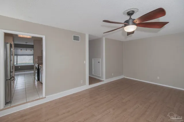 an empty room with closet and a chandelier fan