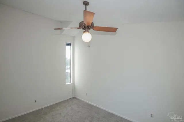 a view of a room with a ceiling fan and window