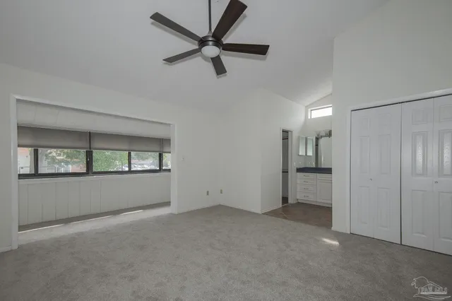 an empty room with a ceiling fan and a window