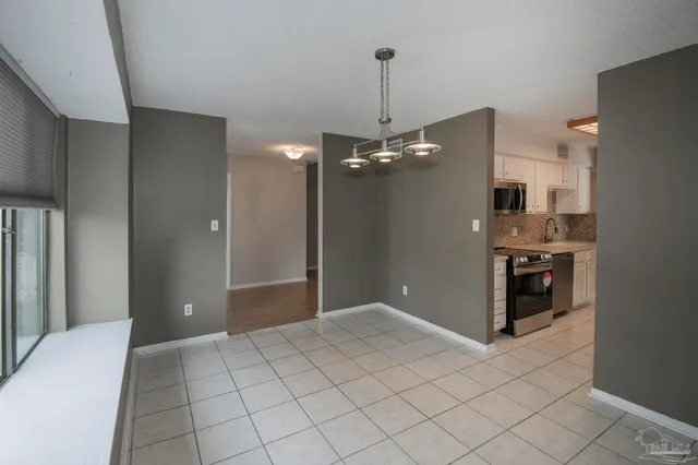 a view of a kitchen with a sink and an empty room