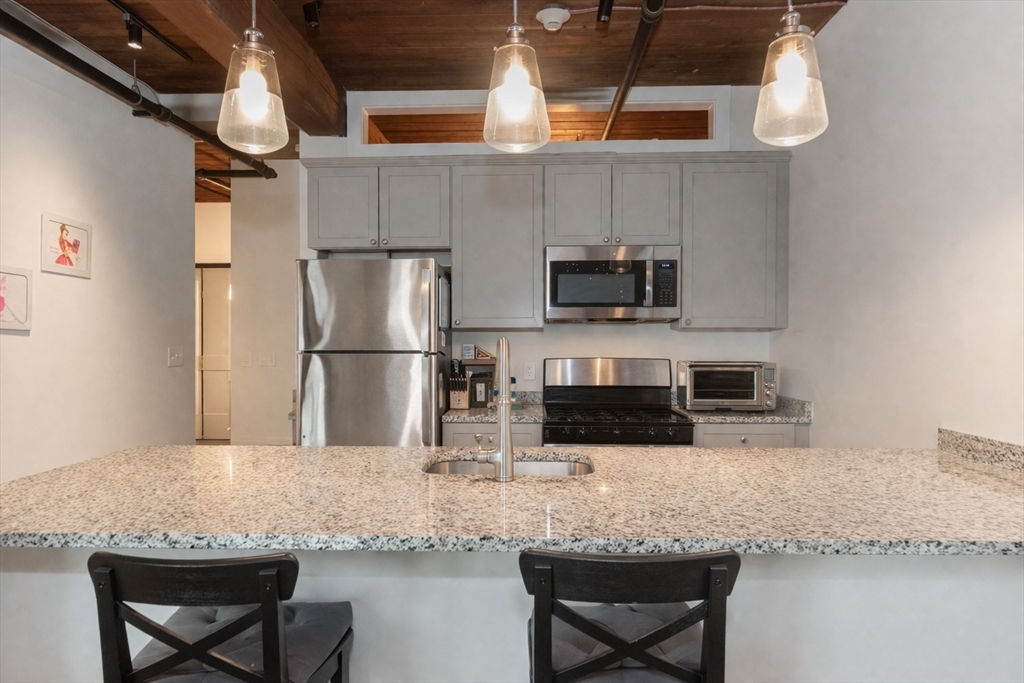 a kitchen with stainless steel appliances granite countertop a sink and a refrigerator
