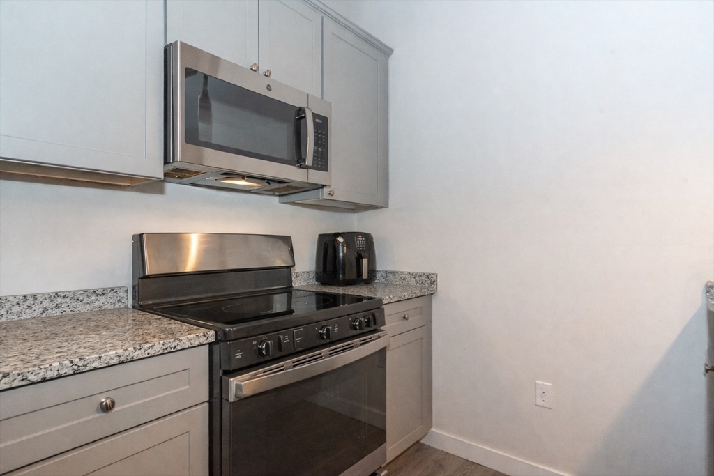 55 Sterling Street, Unit 305 Clinton, MA 01510 - Photo 4 of 31 a kitchen with a stove and a microwave