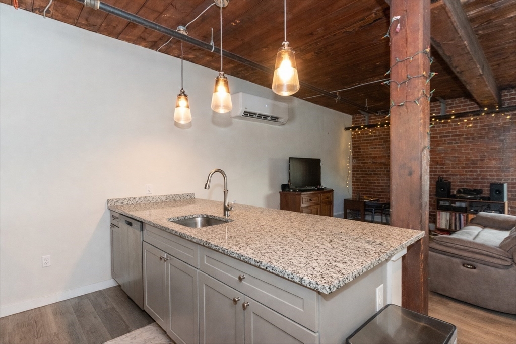 55 Sterling Street, Unit 305 Clinton, MA 01510 - Photo 6 of 31 a kitchen with a sink and chandelier