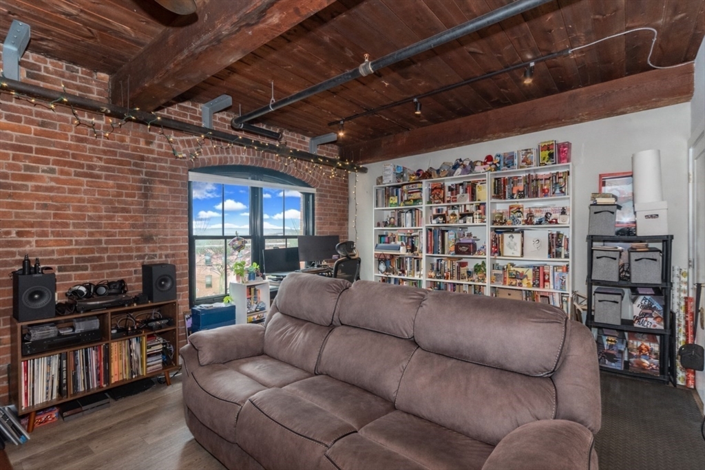 55 Sterling Street, Unit 305 Clinton, MA 01510 - Photo 8 of 31 a living room with furniture and a flat screen tv