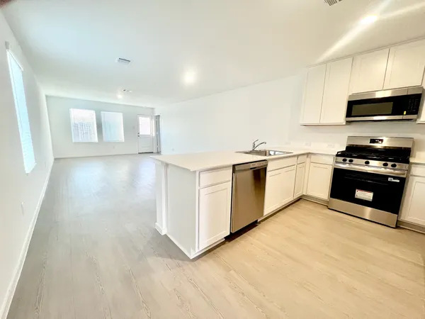 a kitchen with stainless steel appliances granite countertop a stove a sink and a microwave