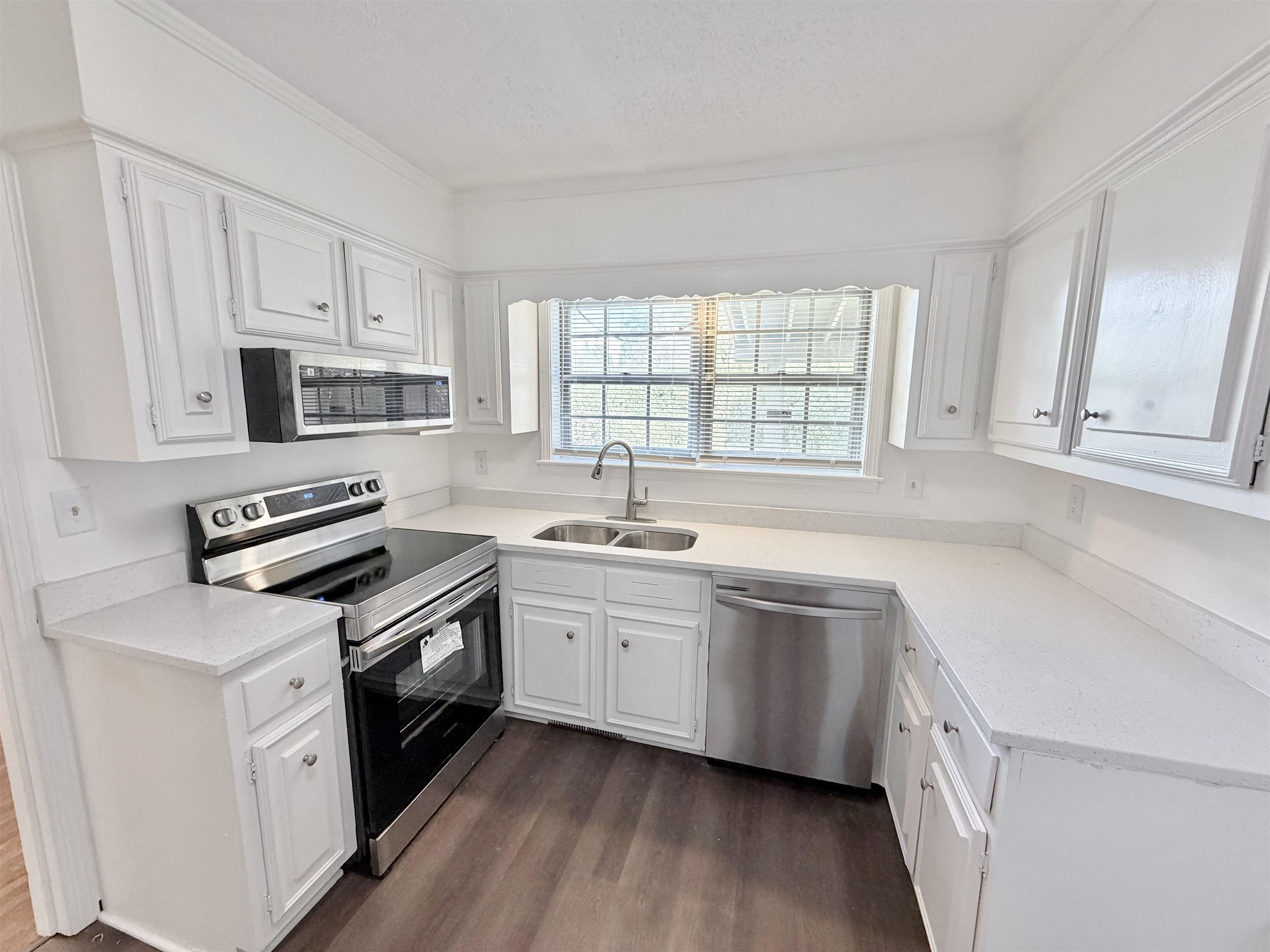 3118 Estes Street Memphis, TN 38115 - Photo 2 of 32 a kitchen with white cabinets appliances a sink and a window