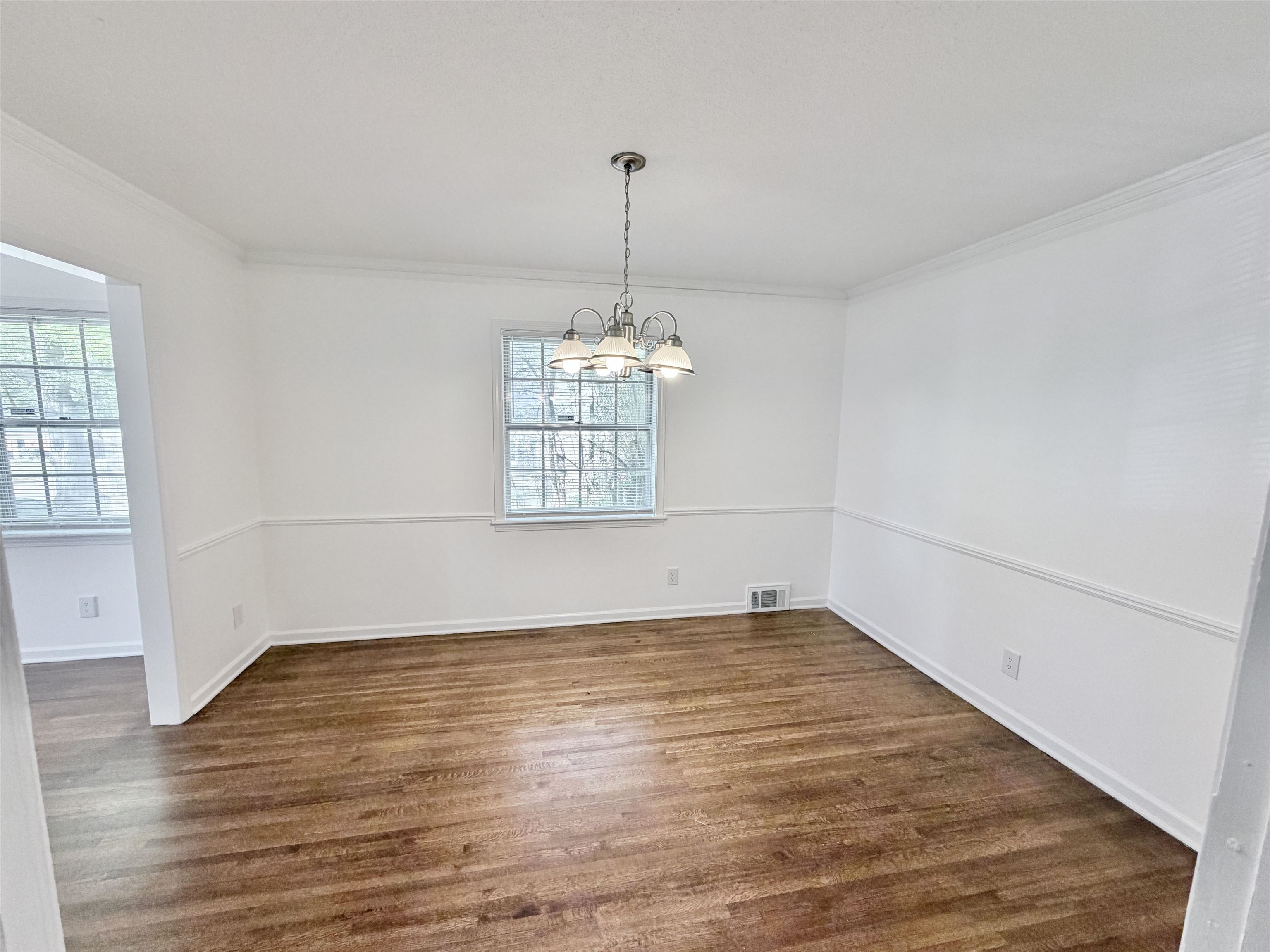 3118 Estes Street Memphis, TN 38115 - Photo 9 of 32 an empty room with wooden floor chandelier and windows