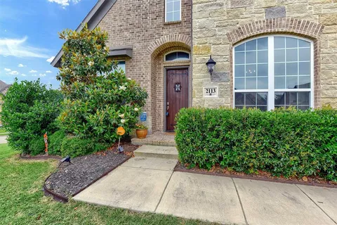 front view of a brick house with a yard
