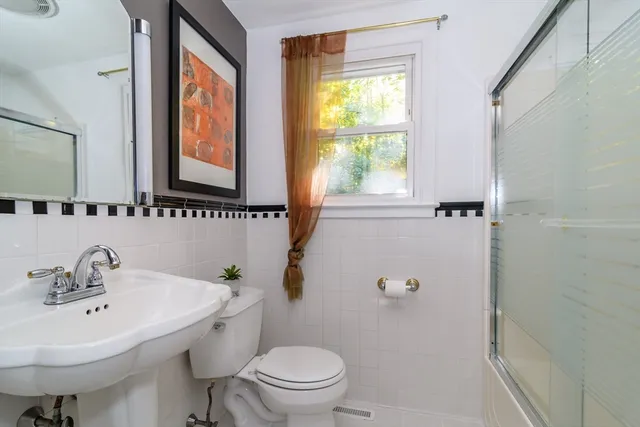 a bathroom with a sink a toilet and a mirror