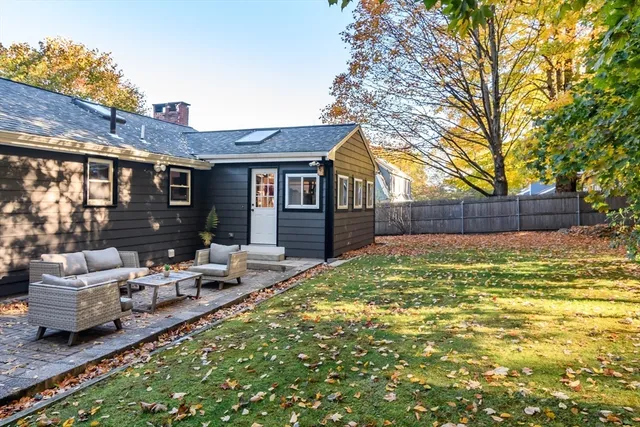 a view of a house with backyard and sitting area
