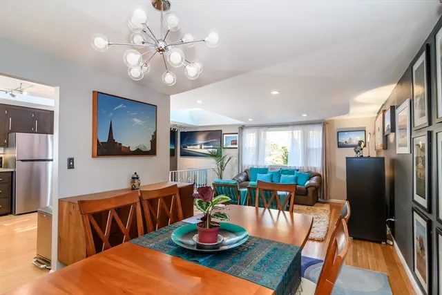 a view of a dining room with furniture a chandelier and wooden floor