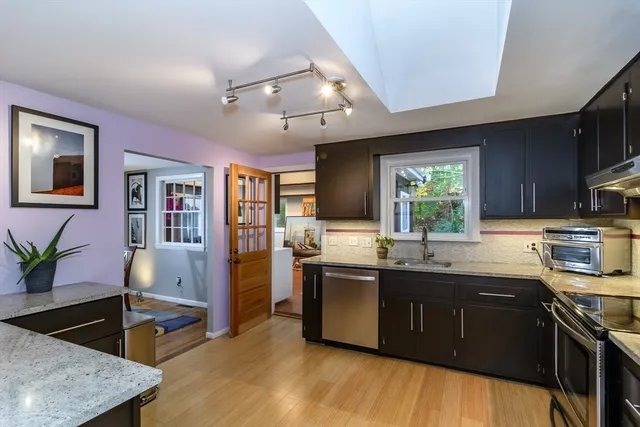 a kitchen with stainless steel appliances granite countertop sink stove top oven and cabinets