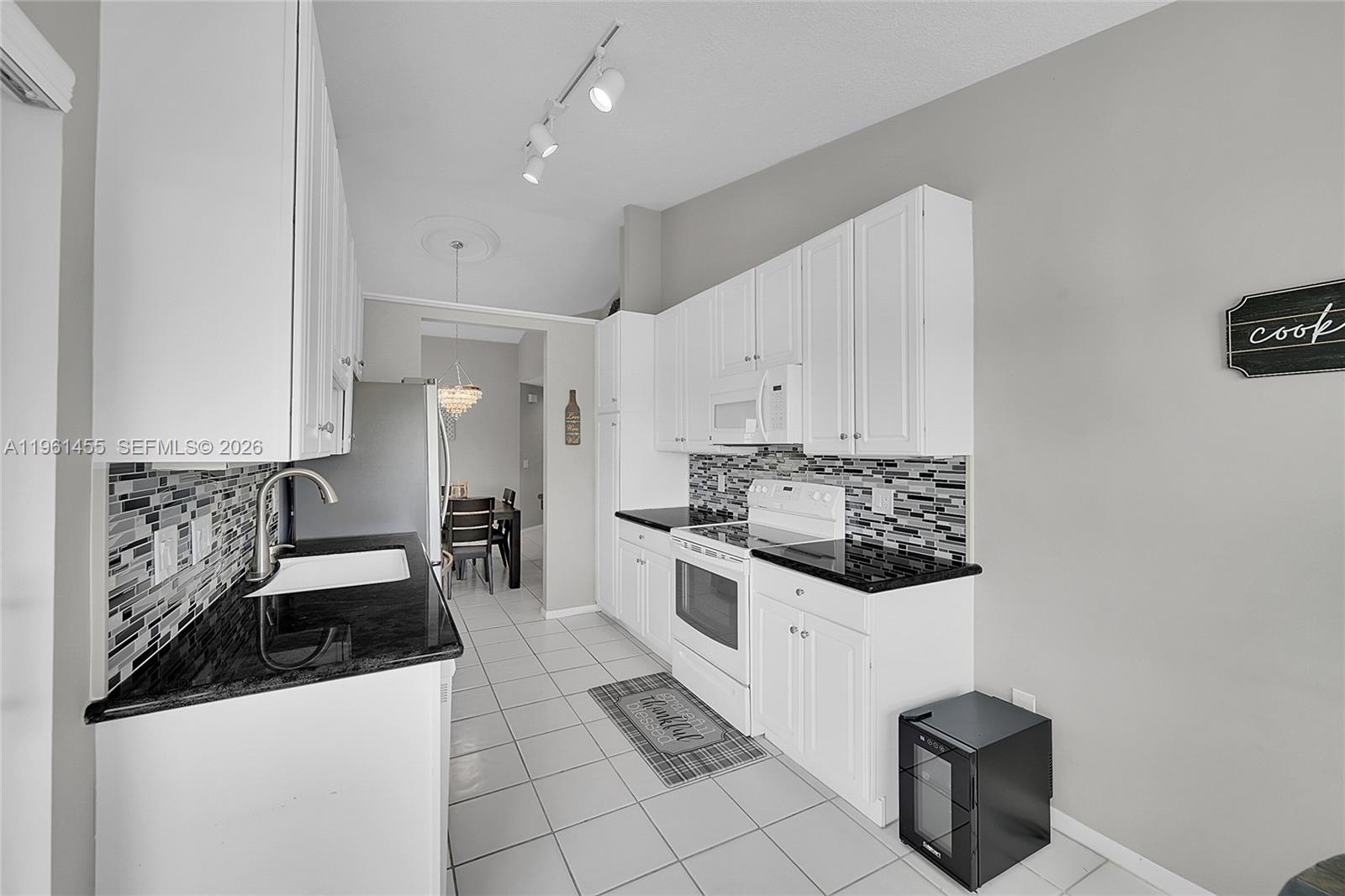 17317 Boca Club Boulevard, Unit 7 Boca Raton, FL 33487 - Photo 23 of 48 a kitchen with granite countertop a stove and a sink