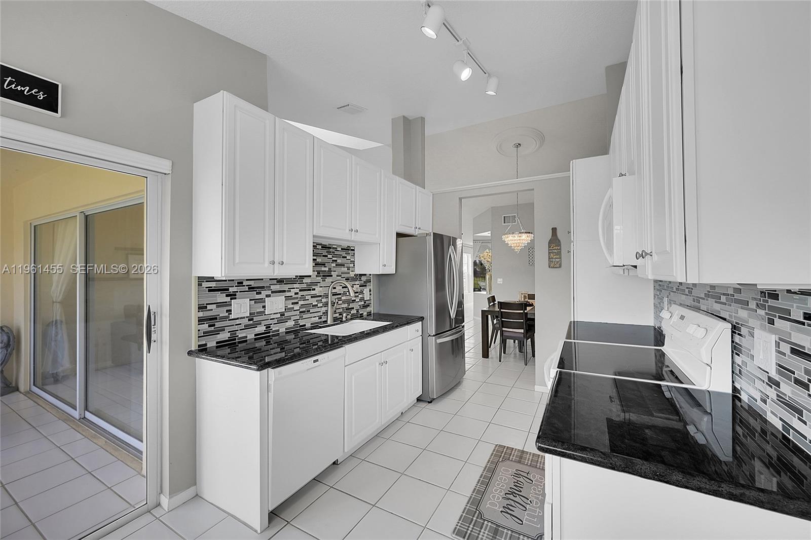 17317 Boca Club Boulevard, Unit 7 Boca Raton, FL 33487 - Photo 3 of 48 a kitchen with granite countertop a sink and stainless steel appliances
