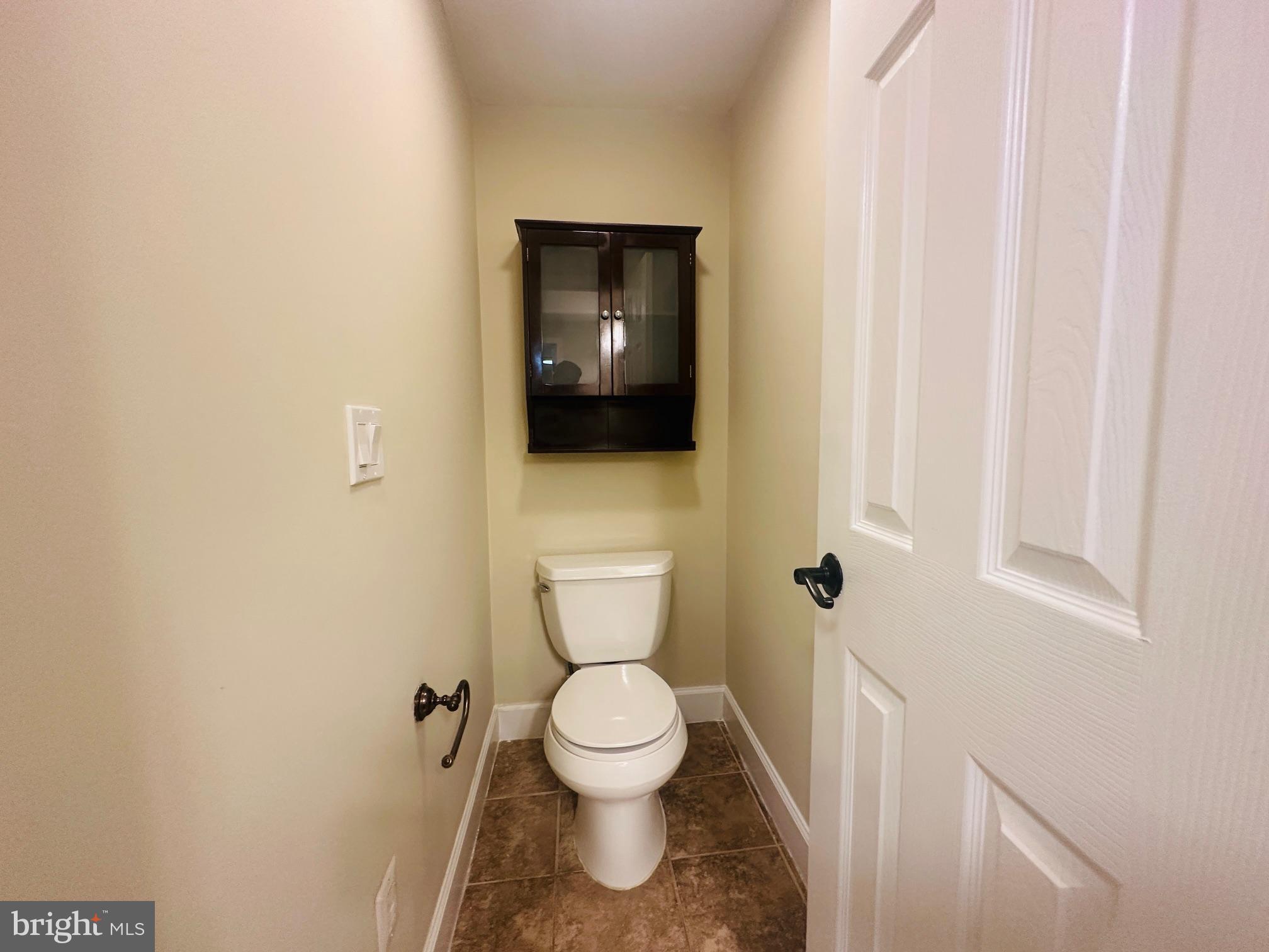 102 Hayloft Circle Sterling, VA 20164 - Photo 27 of 39 a white toilet sitting in a bathroom next to a wooden wall