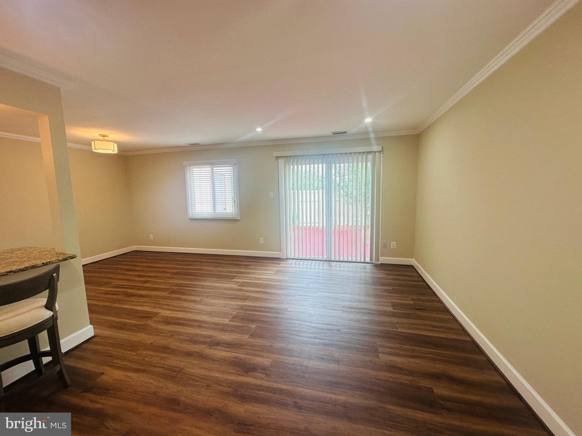 102 Hayloft Circle Sterling, VA 20164 - Photo 6 of 39 a view of an empty room with wooden floor and a window