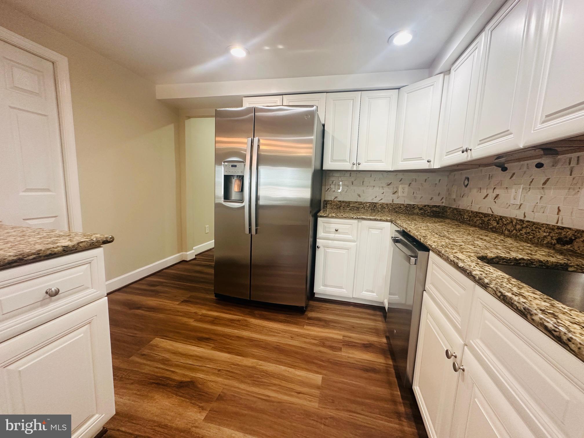 102 Hayloft Circle Sterling, VA 20164 - Photo 7 of 39 a kitchen with granite countertop a refrigerator and a stove top oven