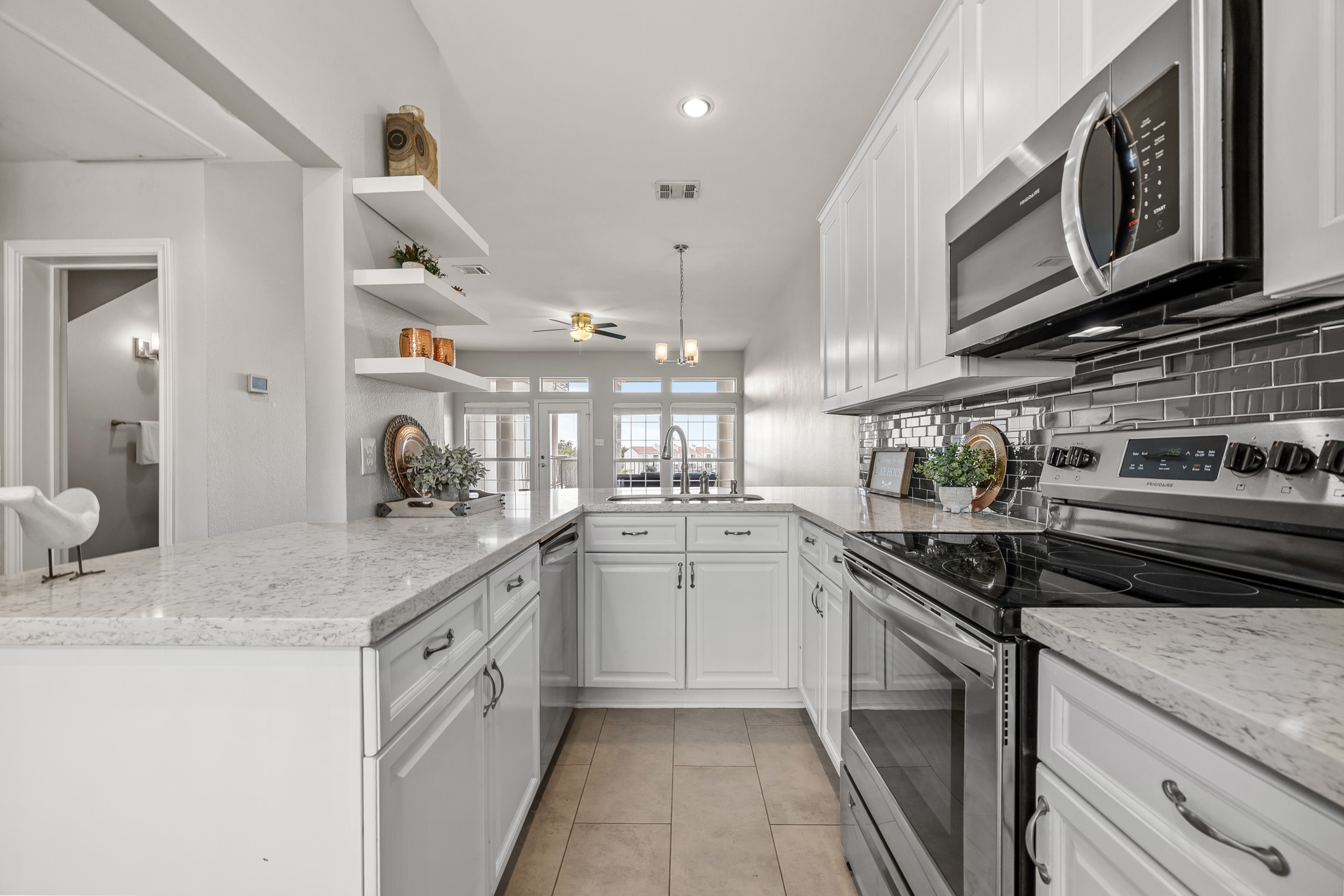2918 Ranch Road 620 North, Unit S242 Austin, TX 78734 - Photo 7 of 35 White cabinetry and stone countertops elevate this kitchen, featuring stainless steel appliances.