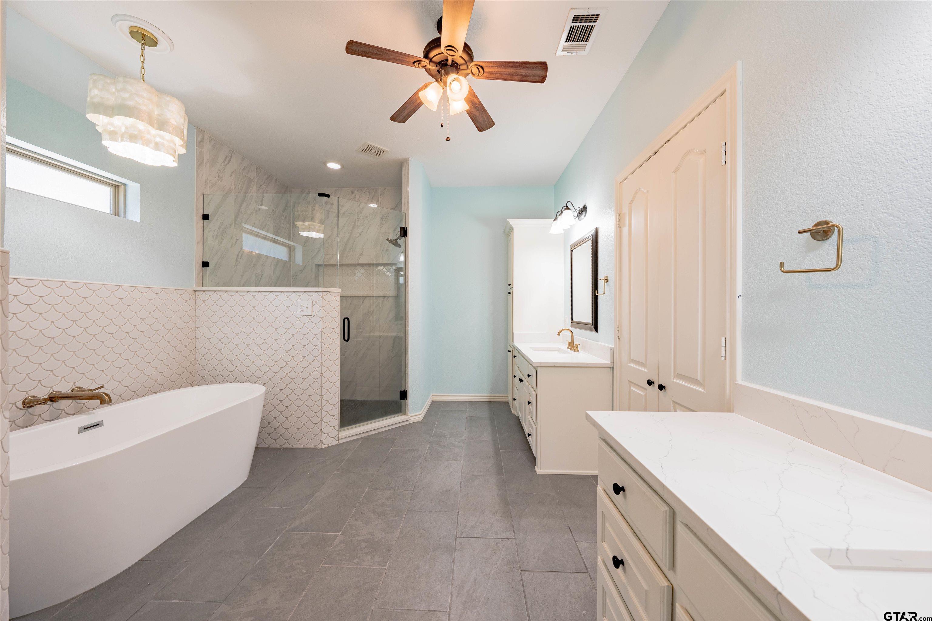 3597 Pedernales North Athens, TX 75752 - Photo 15 of 32 a bathroom with a double vanity sink a mirror a bathtub and shower