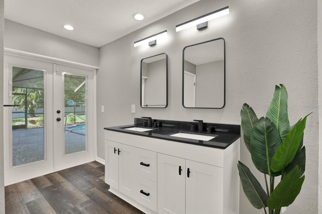 7487 River Country Drive Weeki Wachee, FL 34607 - Photo 34 of 53 a bathroom with a double vanity sink and a mirror