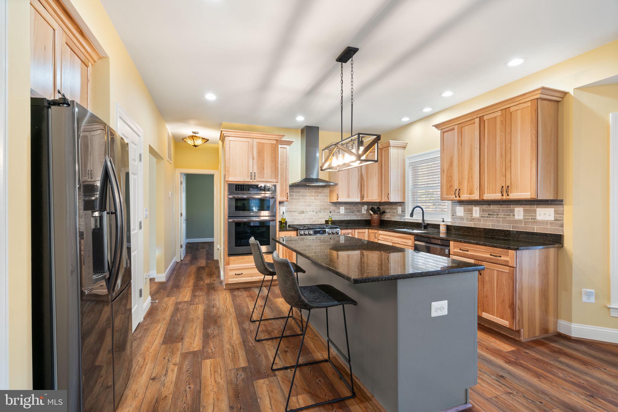 2182 Towles Road Midland, VA 22728 - Photo 14 of 50 a kitchen with stainless steel appliances granite countertop a refrigerator a sink dishwasher a stove and white countertops with wooden floor