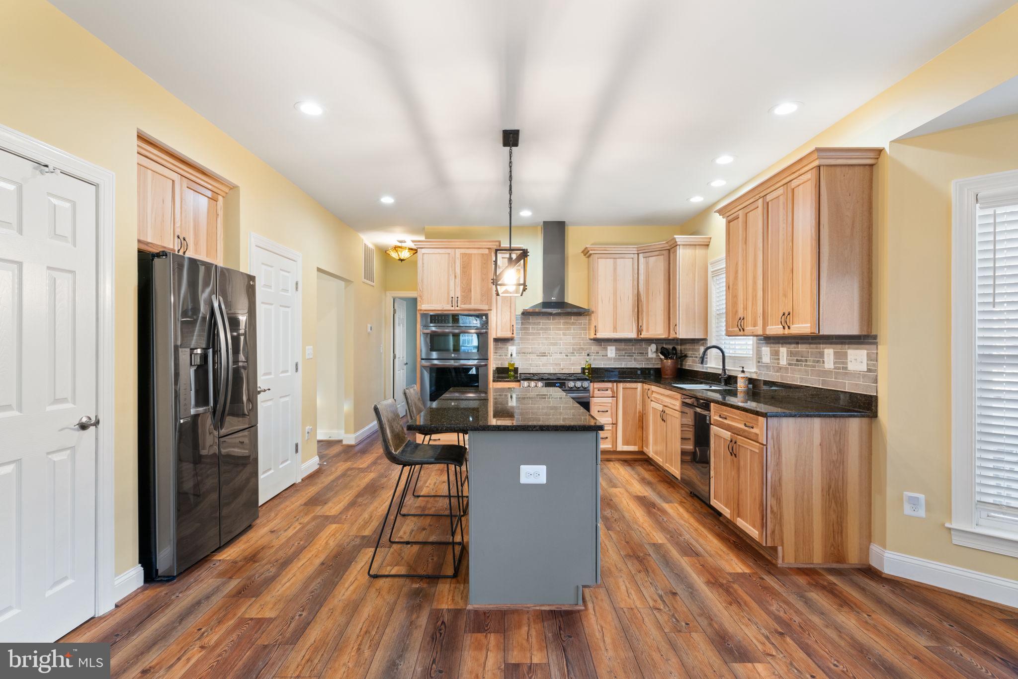 2182 Towles Road Midland, VA 22728 - Photo 15 of 50 a kitchen with a refrigerator a stove top oven and wooden floor