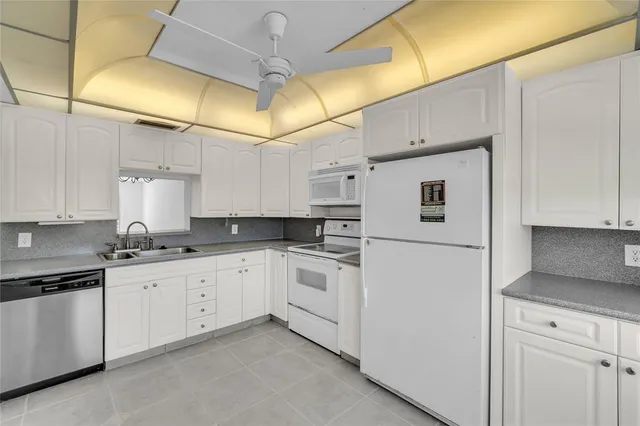 a kitchen with white cabinets and white appliances