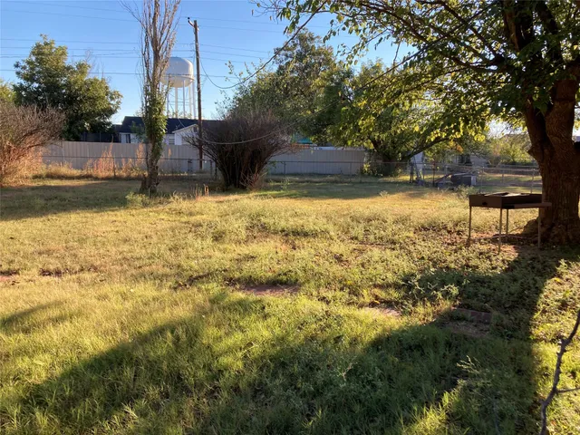 a view of a yard with wooden fence