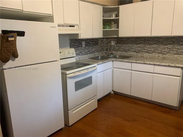 a kitchen with granite countertop cabinets stainless steel appliances and sink