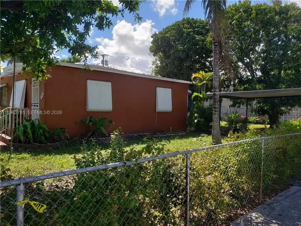 front view of house with a yard and potted plants