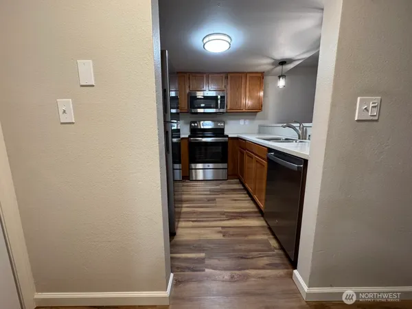a kitchen with granite countertop a refrigerator and a stove top oven
