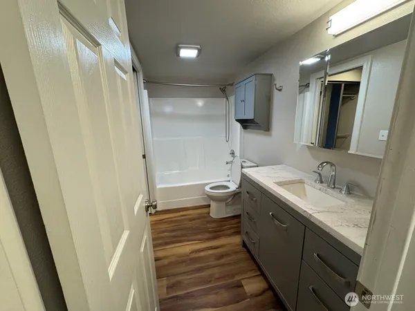 a bathroom with a granite countertop sink toilet and shower