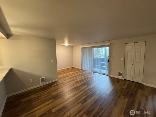 a view of an empty room with wooden floor