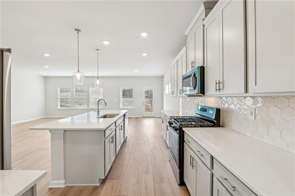 405 Morgan Crk Road Pendergrass, GA 30567 - Photo 14 of 48 a kitchen with stainless steel appliances a sink a stove top oven a counter space and cabinets