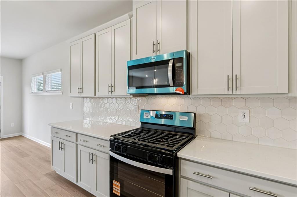 405 Morgan Crk Road Pendergrass, GA 30567 - Photo 20 of 48 a kitchen with stainless steel appliances granite countertop white cabinets and a stove top oven