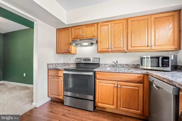 a kitchen with granite countertop cabinets stainless steel appliances and a sink