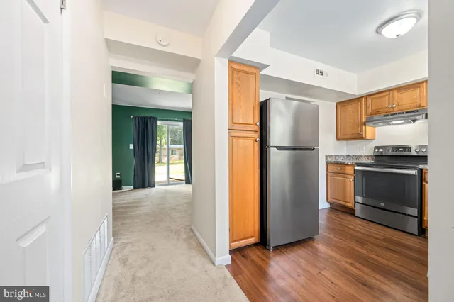 a kitchen with a refrigerator and a stove top oven