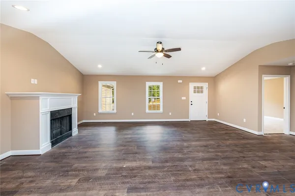 a view of empty room with wooden floor and fireplace