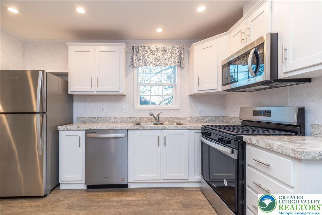 465 Royal Manor Road, Unit LOT 1 Easton, PA 18042 - Photo 2 of 15 a kitchen with stainless steel appliances granite countertop a stove a refrigerator and a microwave