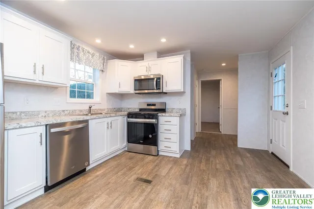 a kitchen with a refrigerator and a stove top oven