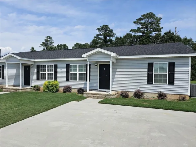 a front view of a house with a yard and outdoor seating