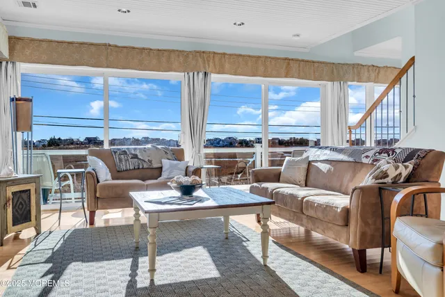 a view of a livingroom with wooden floor and a hallway