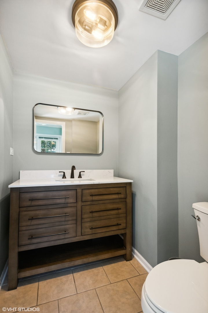 3951 Rutgers Lane Northbrook, IL 60062 - Photo 12 of 22 a bathroom with a sink a mirror and a toilet