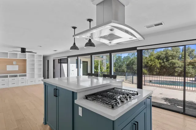 a view of a kitchen with granite countertop a sink and a stove