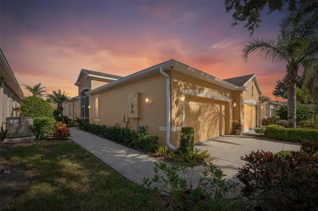 a view of a house with a yard and potted plants