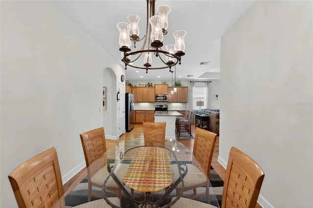 a kitchen with stainless steel appliances granite countertop a sink a stove a refrigerator and island with wooden floor