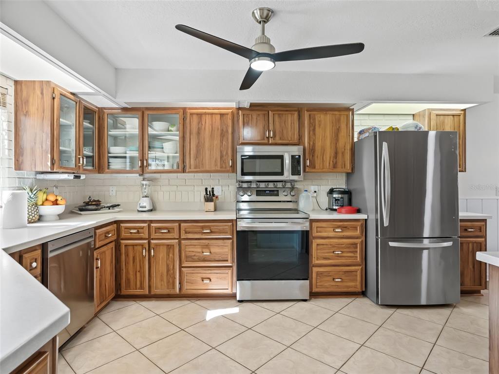 8916 Southwest 8th Street Ocala, FL 34481 - Photo 14 of 40 a kitchen with granite countertop a refrigerator oven a sink and dishwasher