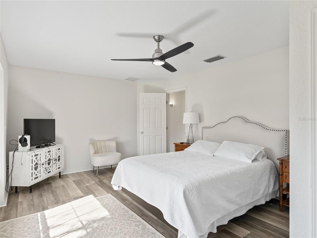 8916 Southwest 8th Street Ocala, FL 34481 - Photo 24 of 40 a bedroom with a bed and a flat tv screen on the dresser