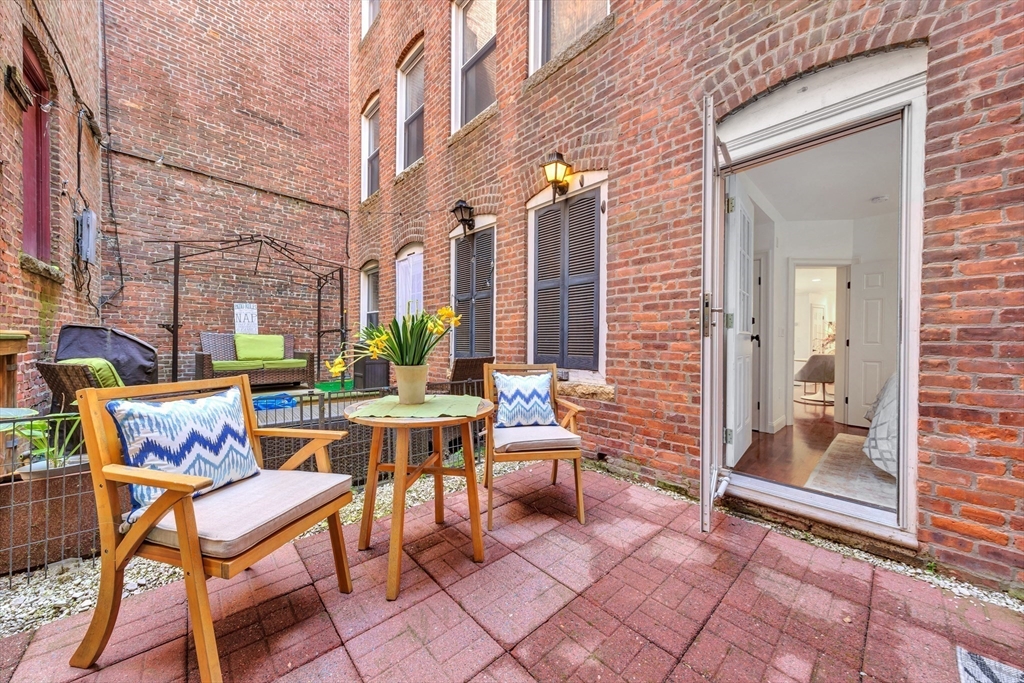 34 Clark Street, Unit 2 Boston, MA 02113 - Photo 17 of 23 a view of a patio with a table and chairs and floor to ceiling window